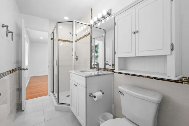 a bathroom with a sink a toilet and shower