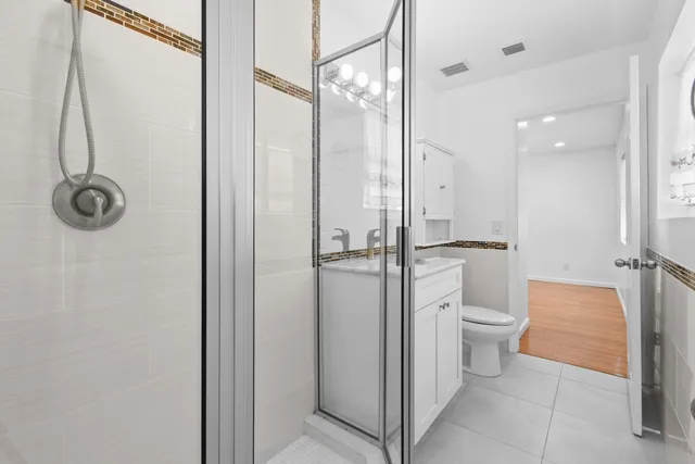 a bathroom with a granite countertop a toilet and a shower