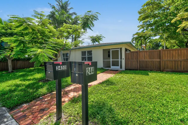 a view of a house with backyard and a tree