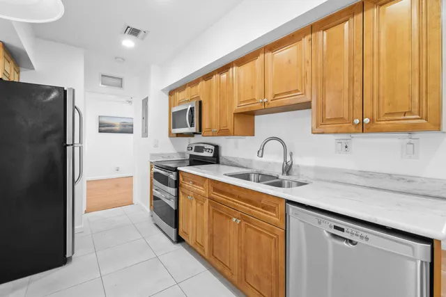 a kitchen with stainless steel appliances granite countertop a refrigerator and a sink
