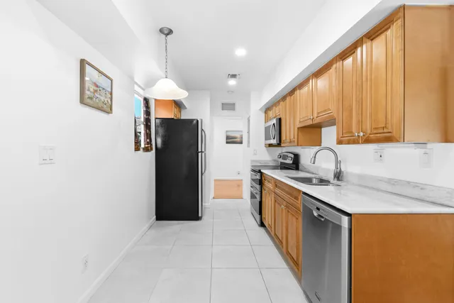 a kitchen with a sink a refrigerator and cabinets