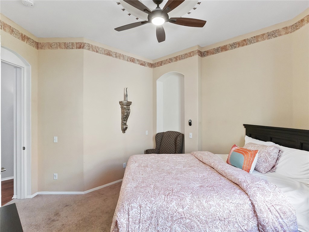 48957 Heifitz Drive Indio, CA 92201 - Photo 14 of 34 a bedroom with a bed and a chandelier