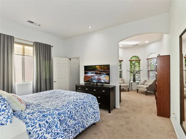 a bedroom with a bed and dresser with mirror