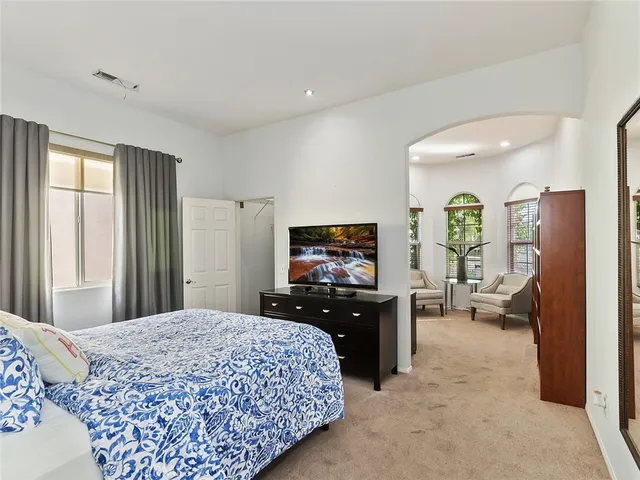 a bedroom with a bed and dresser with mirror