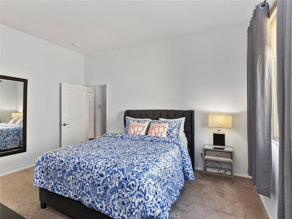 48957 Heifitz Drive Indio, CA 92201 - Photo 17 of 34 a bedroom with a bed and a mirror