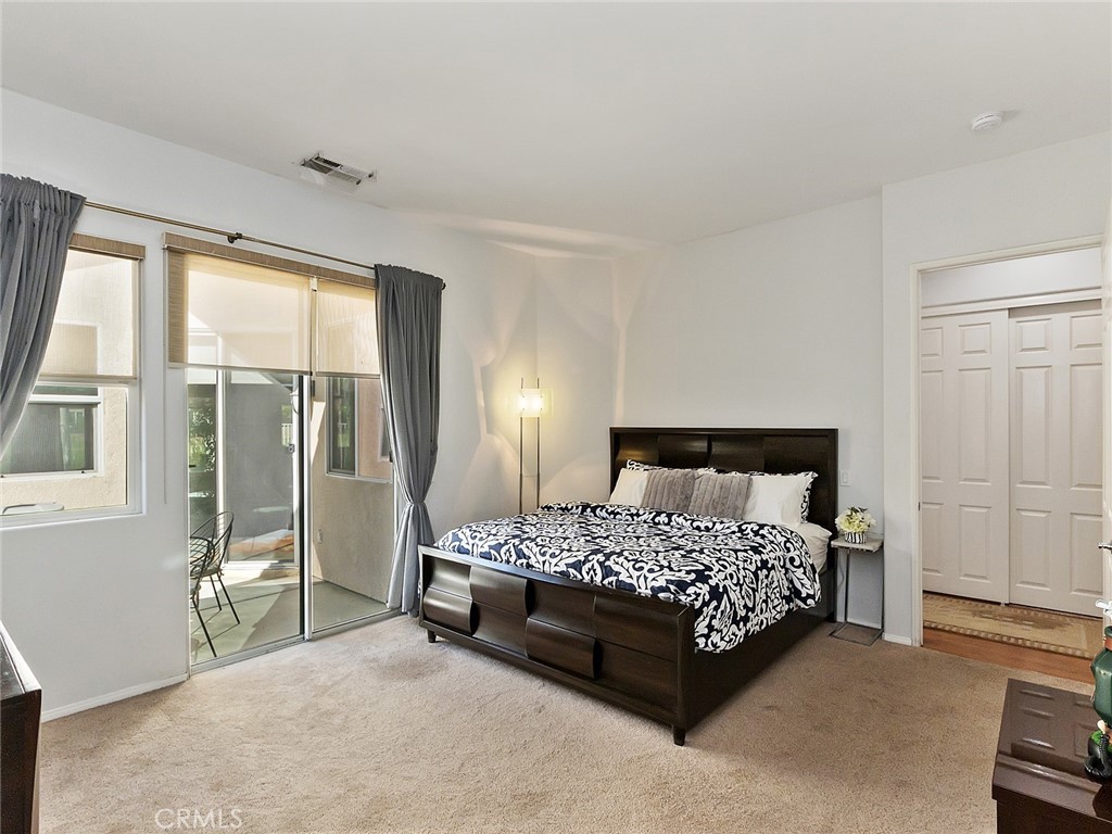48957 Heifitz Drive Indio, CA 92201 - Photo 21 of 34 a bedroom with a bed lamp and a large window