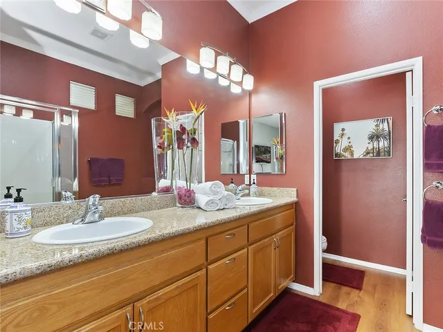 a bathroom with a granite countertop sink a large mirror and a shower