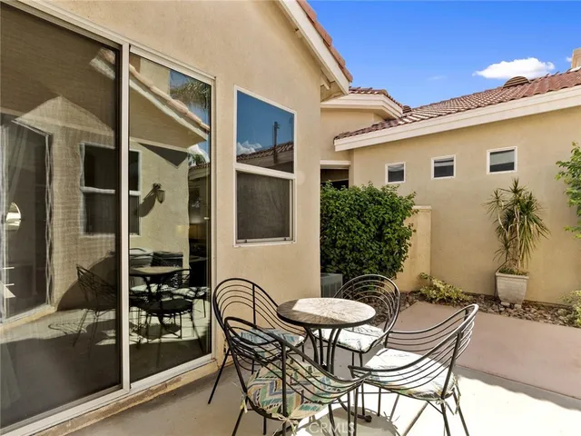 a backyard of a house with table and chairs