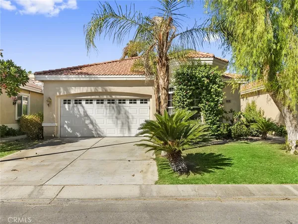 a front view of a house with a garden and a garage