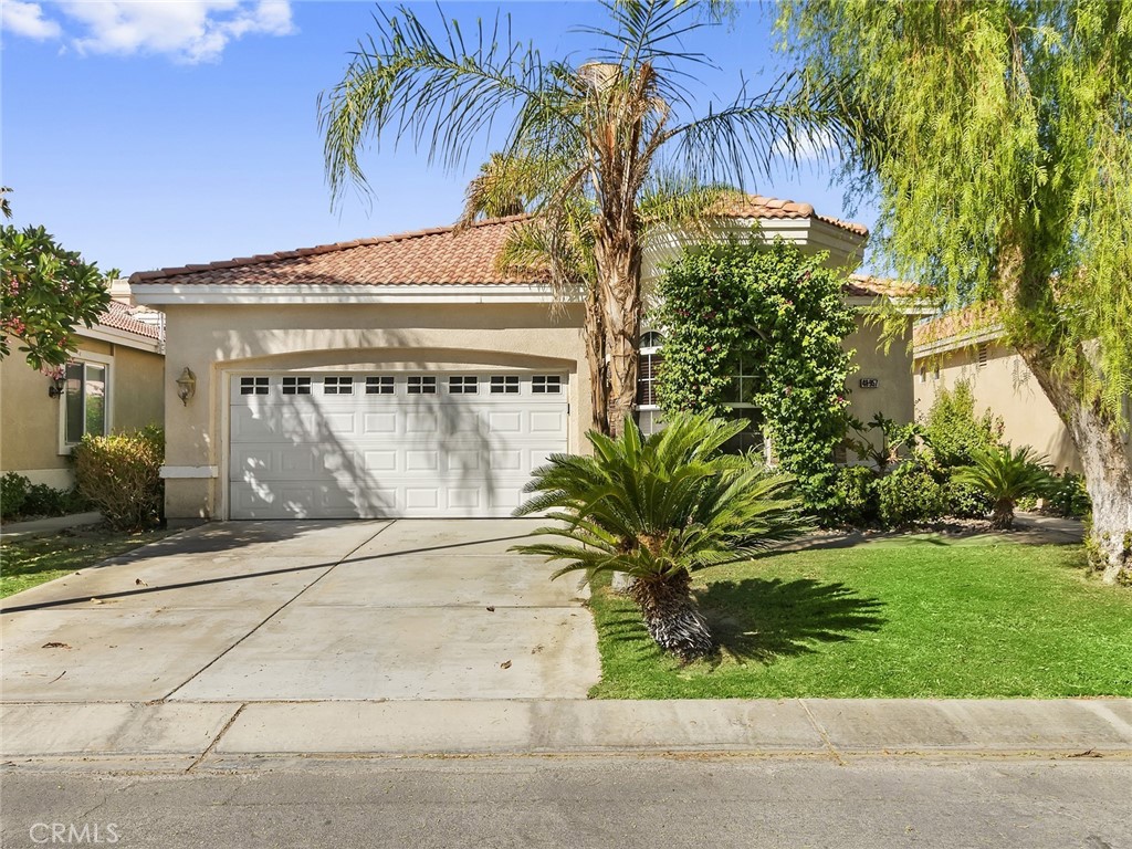 48957 Heifitz Drive Indio, CA 92201 - Photo 33 of 34 a front view of a house with a garden and a garage