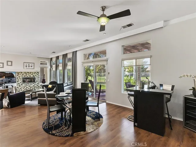 a living room with furniture large window and wooden floor