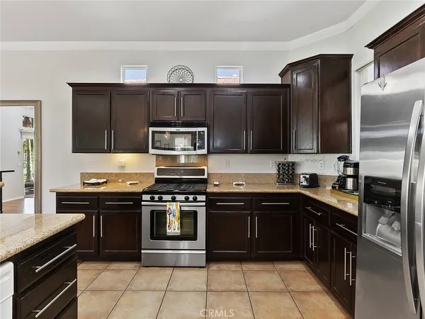 a kitchen with stainless steel appliances granite countertop a stove top oven a sink dishwasher a refrigerator and a microwave