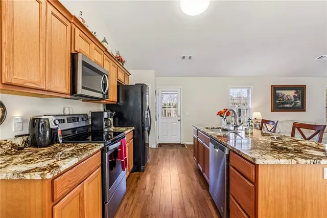 a kitchen with stainless steel appliances granite countertop a stove a sink dishwasher and a refrigerator