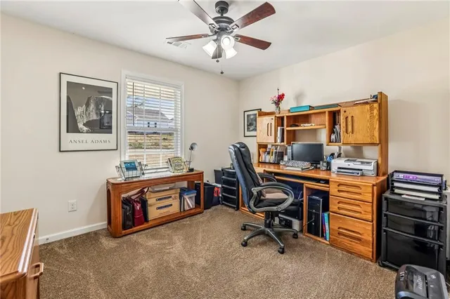 a view of a workspace with furniture and a window