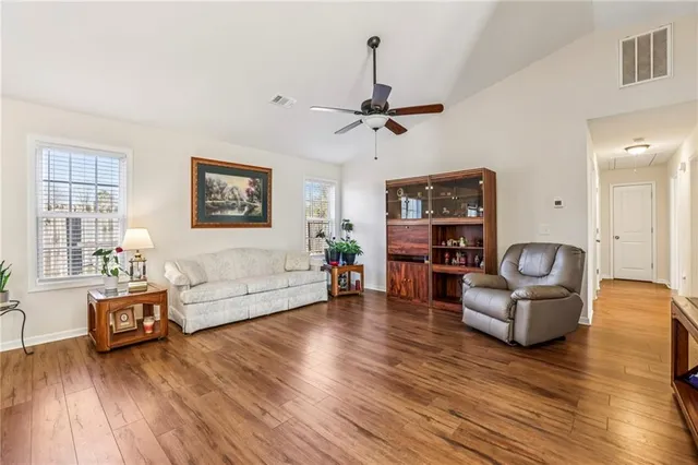 a living room with furniture and a wooden floor