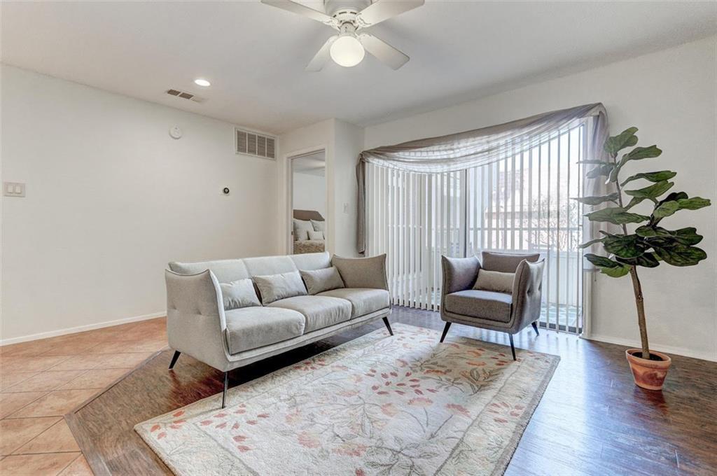 3115 Helms Street, Unit 204 Austin, TX 78705 - Photo 1 of 13 This living area features a bright atmosphere, with wood and tile flooring, and a glass sliding door leading to the exterior.