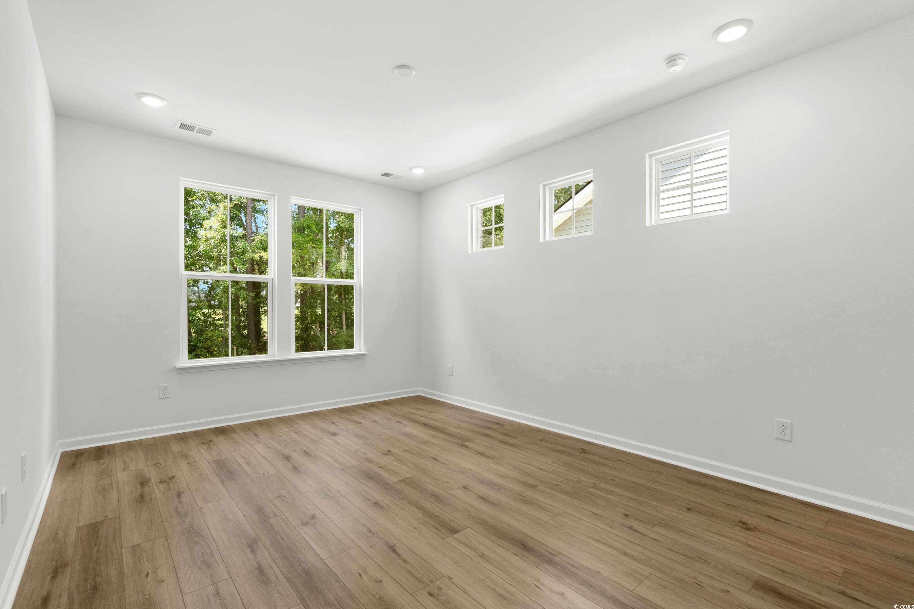 444 Sun Colony Boulevard Longs, SC 29568 - Photo 15 of 31 Primary bedroom featuring 9ft ceilings, 6ft windows, additional windows for natural light, and LVP throughout.