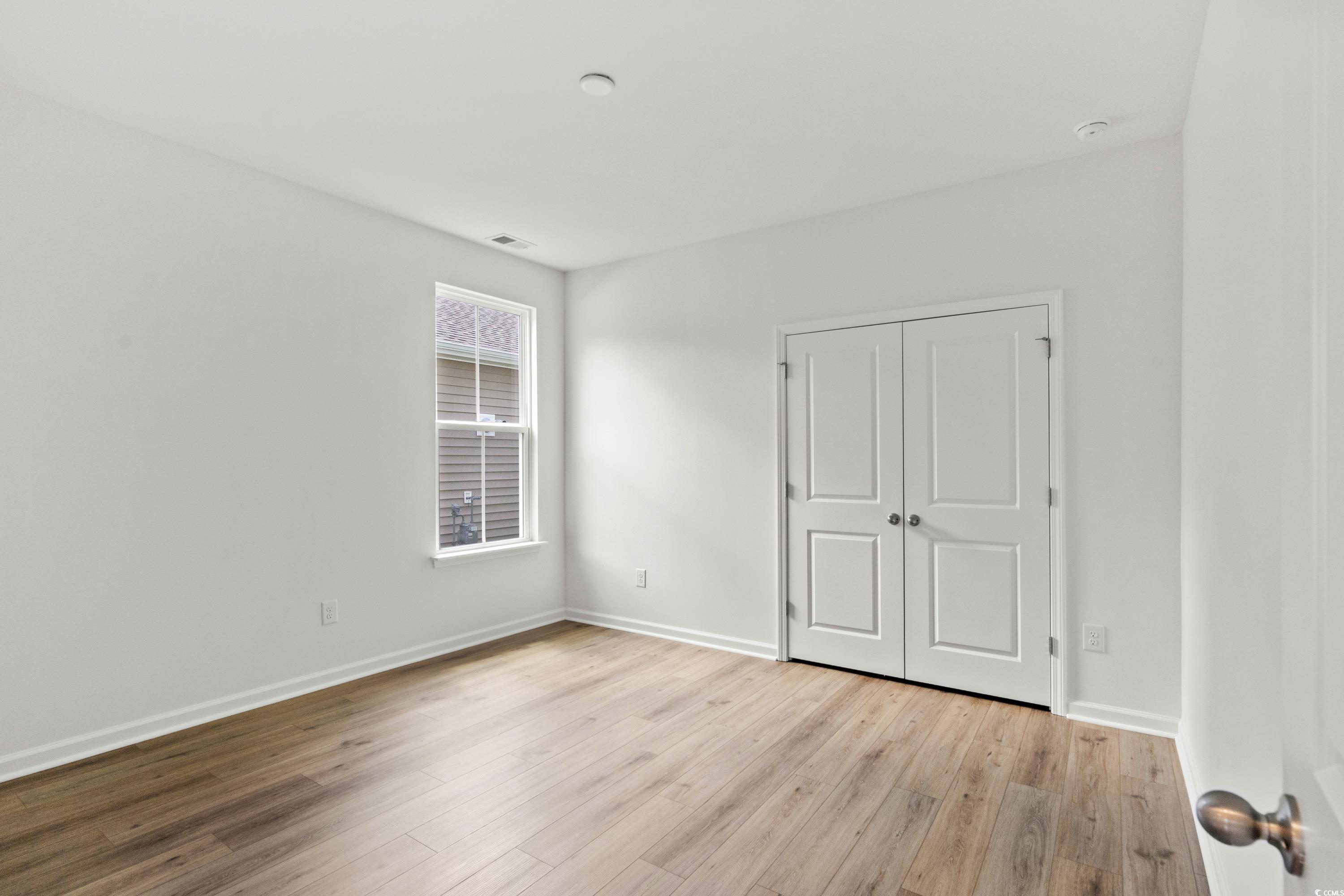 444 Sun Colony Boulevard Longs, SC 29568 - Photo 22 of 31 Unfurnished bedroom with wood finished floors and a closet