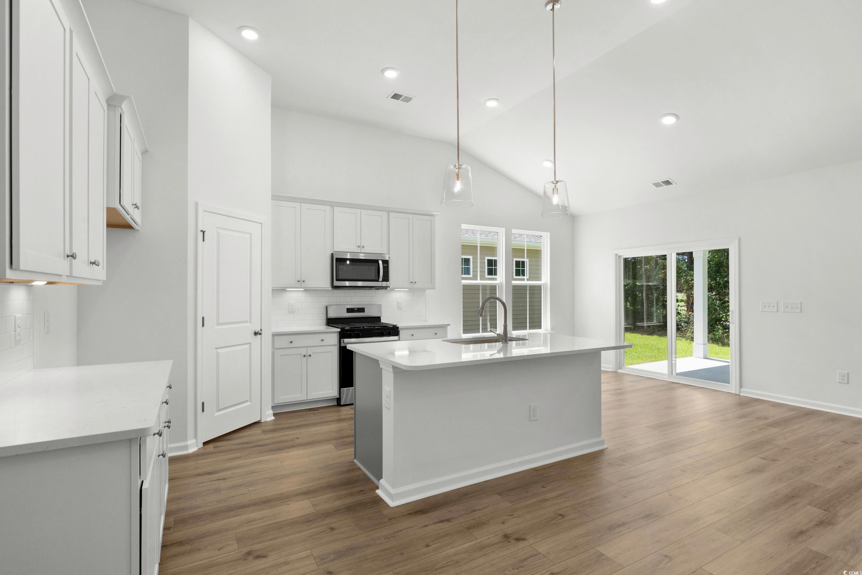 444 Sun Colony Boulevard Longs, SC 29568 - Photo 10 of 31 Kitchen featuring stainless steel gas appliances, upgraded white cabinets with crown molding, quartz countertops, pendant lighting and brushed satin nickel fixtures.