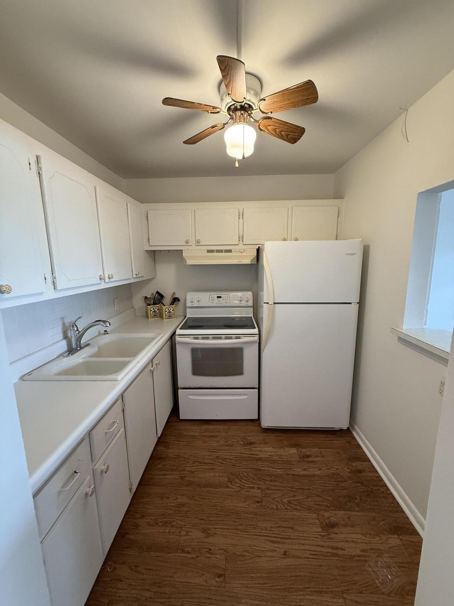a kitchen with a refrigerator sink and cabinets