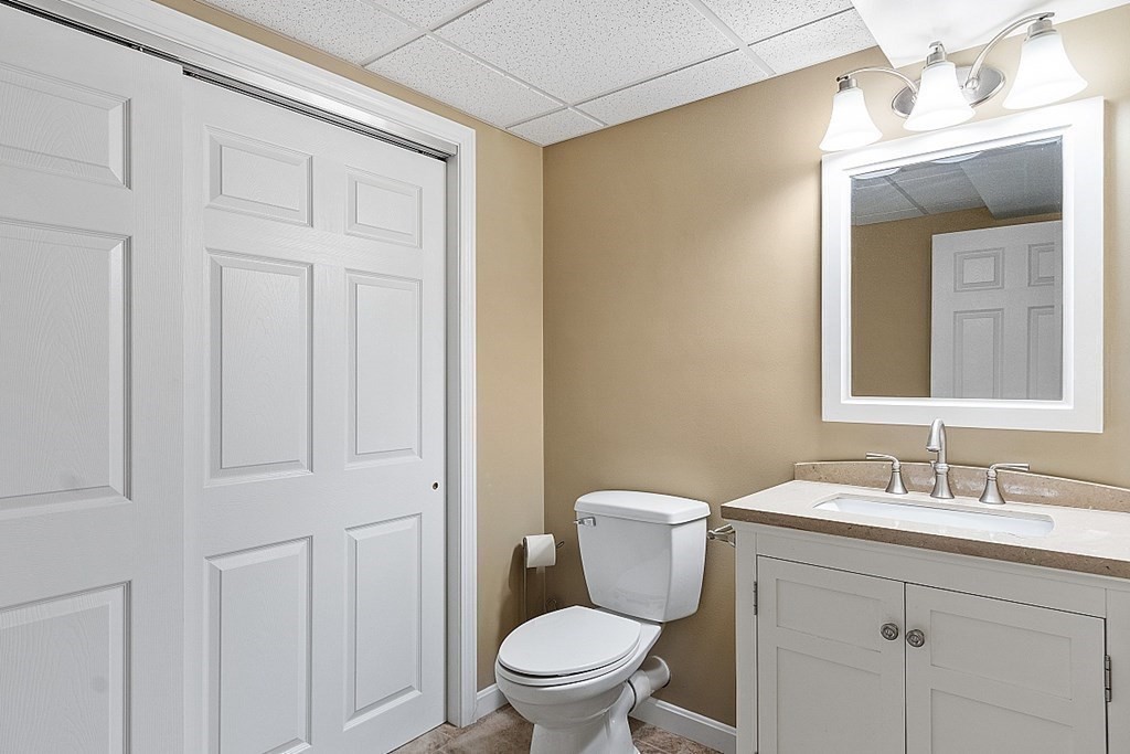 113 Hidden Valley Road Groton, MA 01450 - Photo 30 of 42 a bathroom with a toilet a sink a vanity and mirror