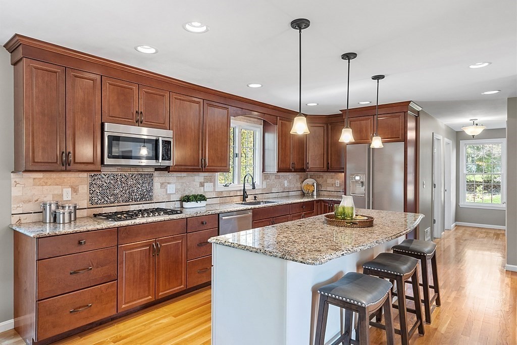113 Hidden Valley Road Groton, MA 01450 - Photo 3 of 42 a kitchen with granite countertop wooden cabinets and stainless steel appliances