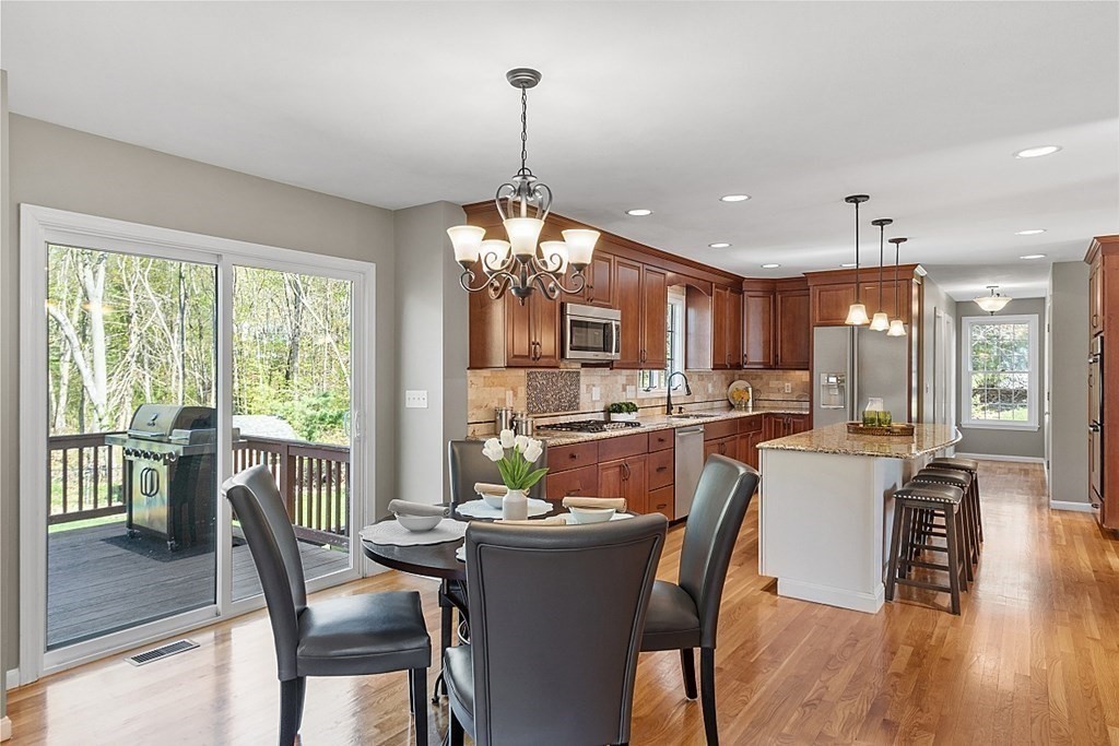 113 Hidden Valley Road Groton, MA 01450 - Photo 5 of 42 a dining room with furniture a chandelier and wooden floor