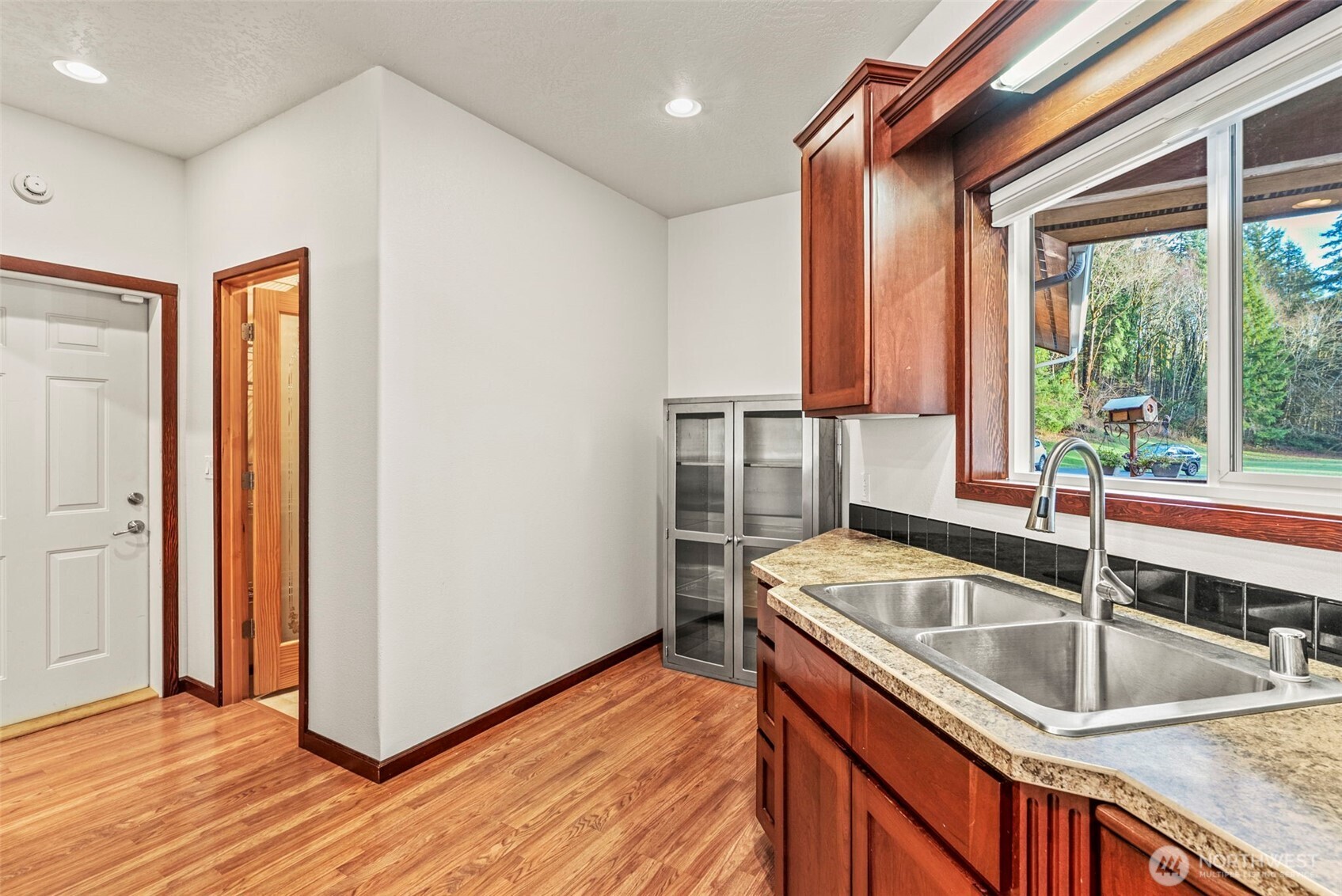 303 Shadow Mountain Road Silverlake, WA 98645 - Photo 11 of 39 a kitchen that has a sink a stove and a wooden floor