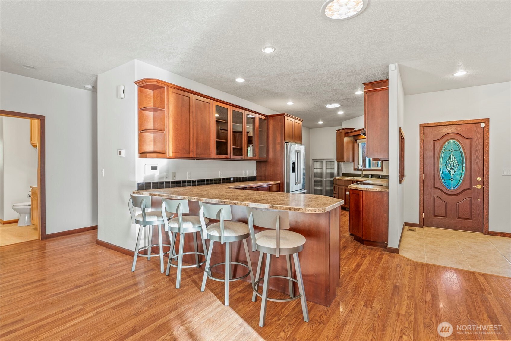 303 Shadow Mountain Road Silverlake, WA 98645 - Photo 14 of 39 a kitchen with stainless steel appliances granite countertop a table chairs and a refrigerator