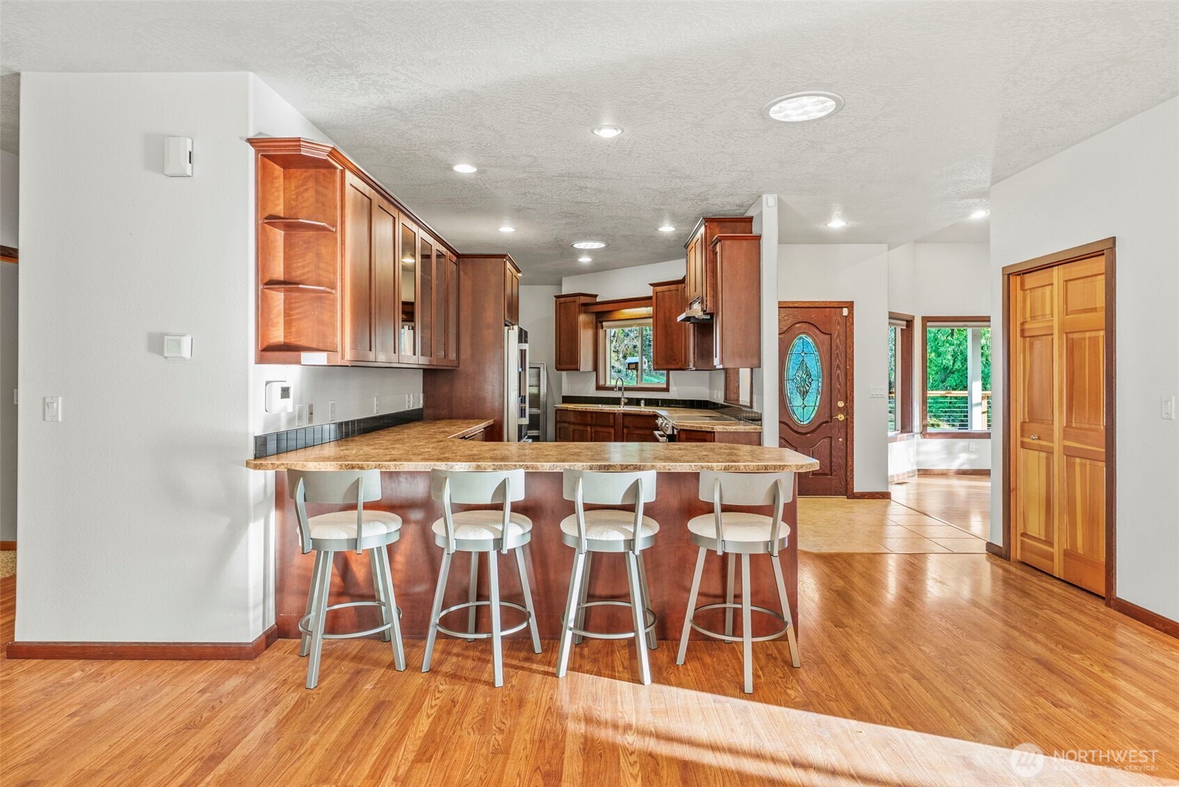 303 Shadow Mountain Road Silverlake, WA 98645 - Photo 15 of 39 a kitchen with stainless steel appliances kitchen island granite countertop a table chairs and a refrigerator