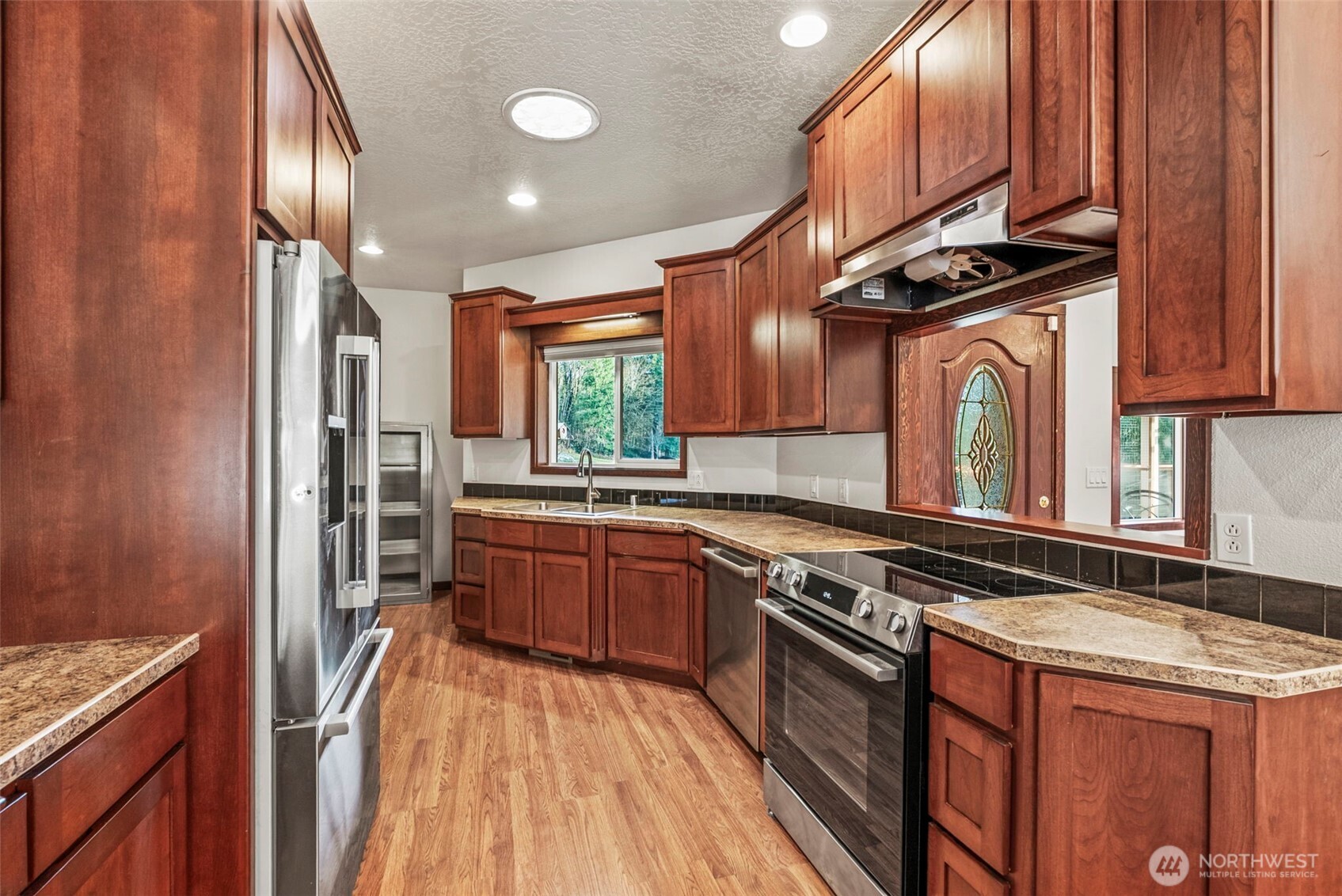 303 Shadow Mountain Road Silverlake, WA 98645 - Photo 10 of 39 a kitchen with stainless steel appliances granite countertop a stove a sink and a refrigerator
