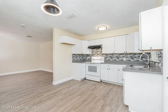 a kitchen with granite countertop a sink and a stove top oven
