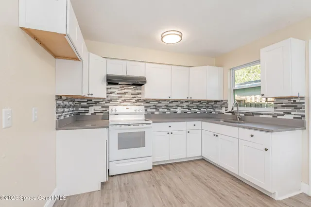 a kitchen with granite countertop white cabinets and white appliances