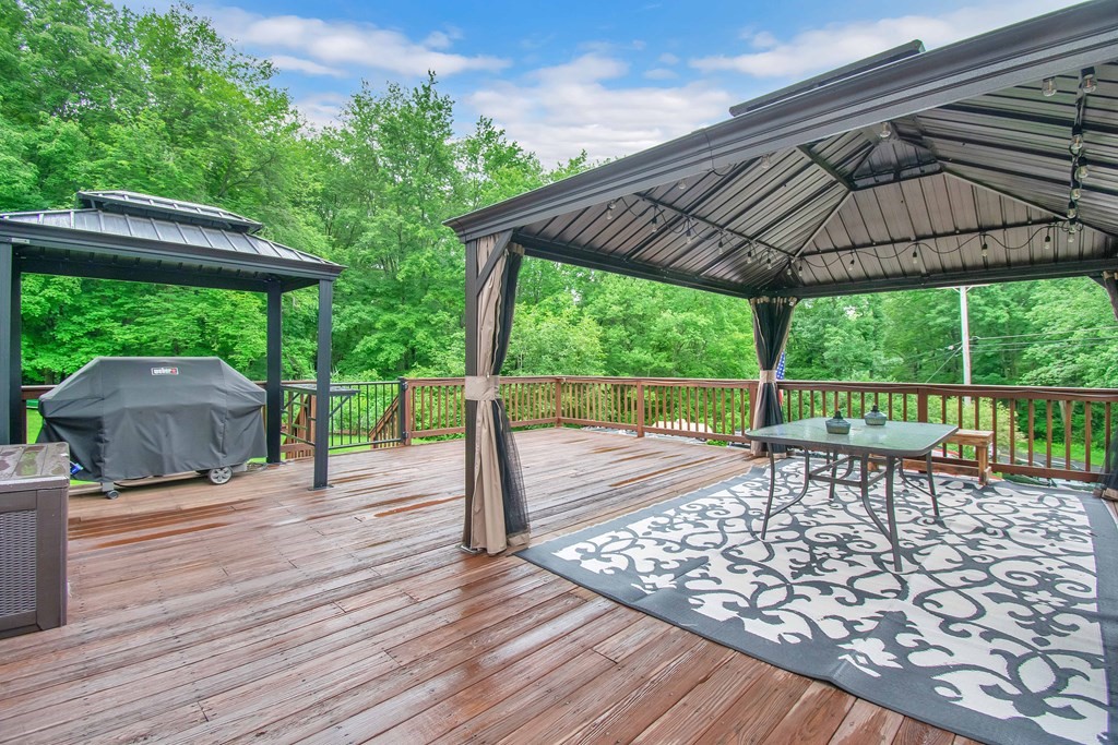 130 Warren Road Brimfield, MA 01010 - Photo 22 of 29 a view of a patio with table and chairs under an umbrella with a small yard