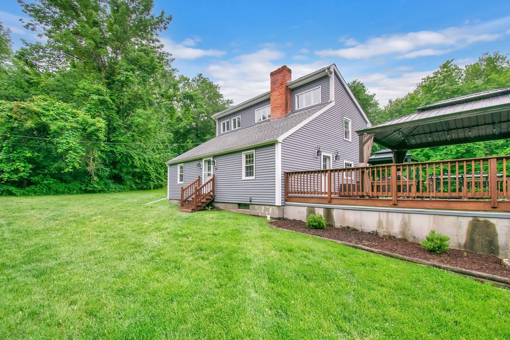 130 Warren Road Brimfield, MA 01010 - Photo 28 of 29 a view of a house with a yard and a wooden deck