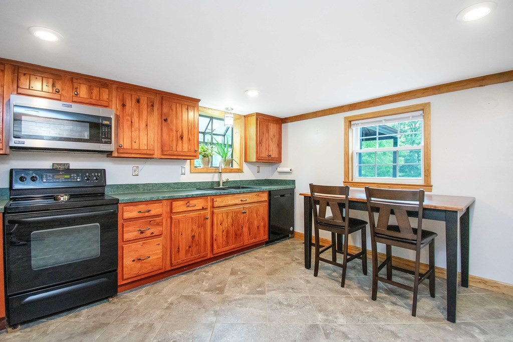 130 Warren Road Brimfield, MA 01010 - Photo 3 of 29 a kitchen with stainless steel appliances granite countertop wooden cabinets a stove a sink and a microwave