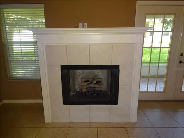 a view of an empty room with a fireplace and a window