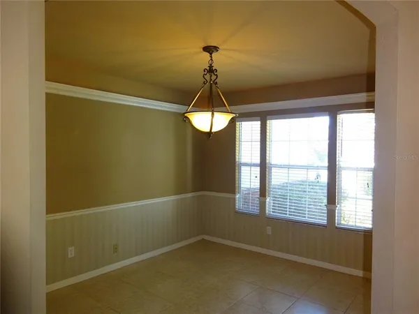 a view of a room with a chandelier fan and windows