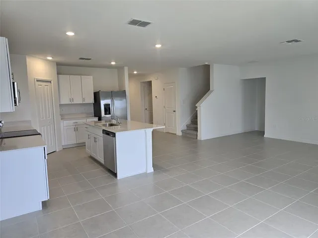 a large kitchen with a large counter top stainless steel appliances and cabinets