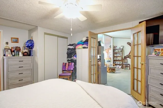 a bedroom with a bed a flat screen tv and a dresser