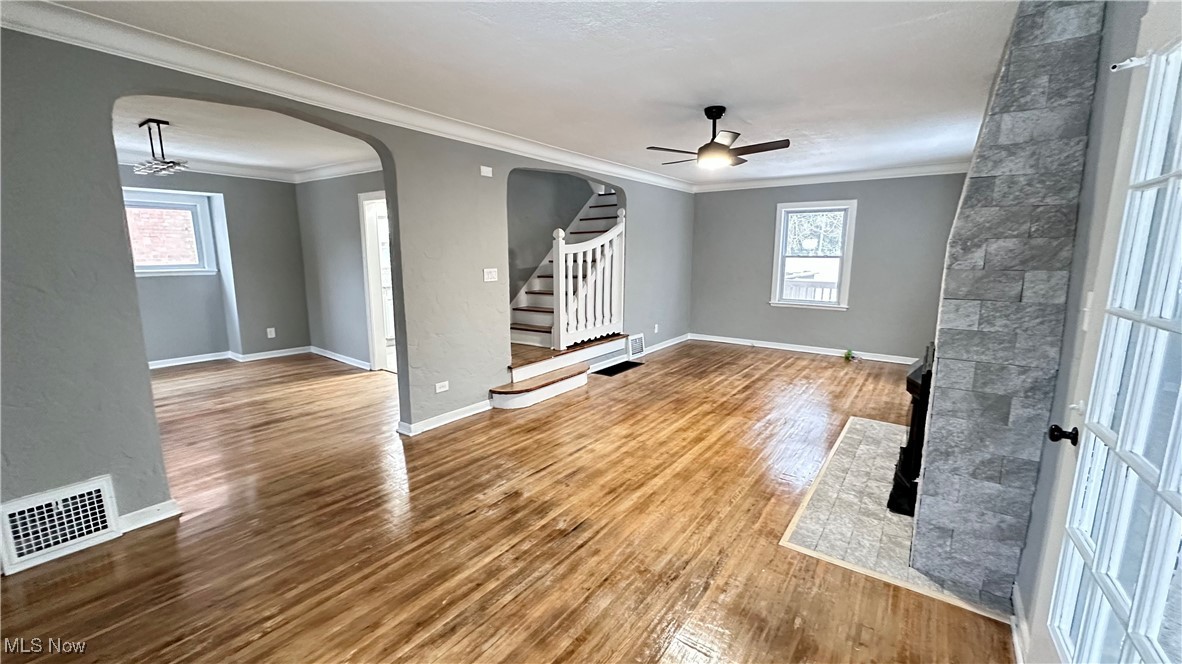 1914 Seneca Road Euclid, OH 44117 - Photo 6 of 30 Unfurnished living room with arched walkways, a ceiling fan, visible vents, and wood finished floors