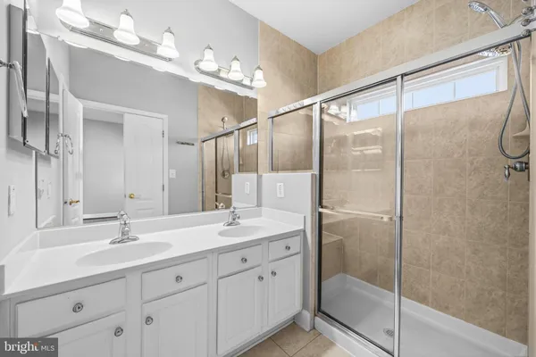 a bathroom with a shower sink and mirror