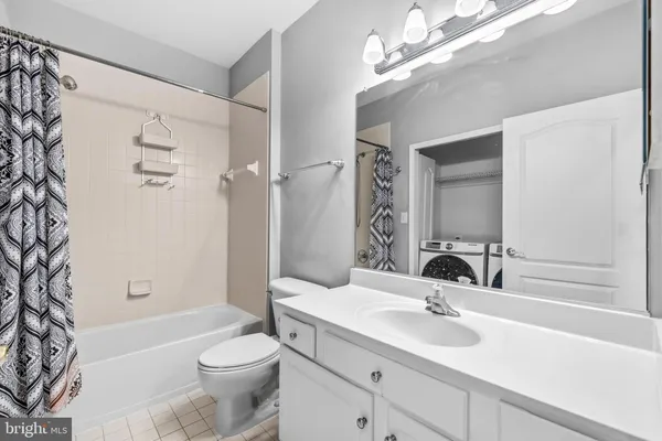 a bathroom with a sink a toilet a mirror a vanity and bathtub