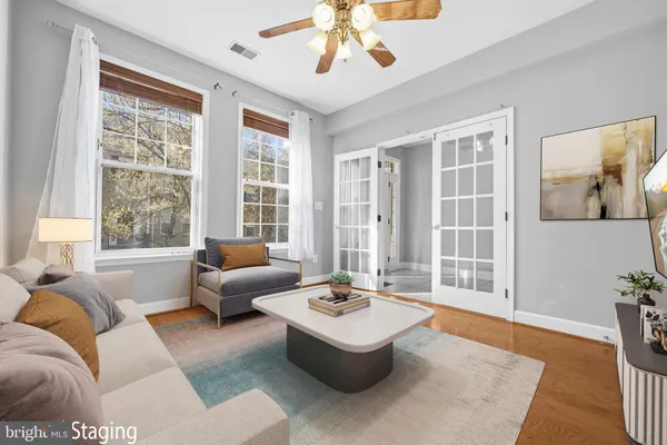 an empty room with a window and a chandelier fan