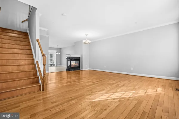 a view of empty room with wooden floor and fireplace