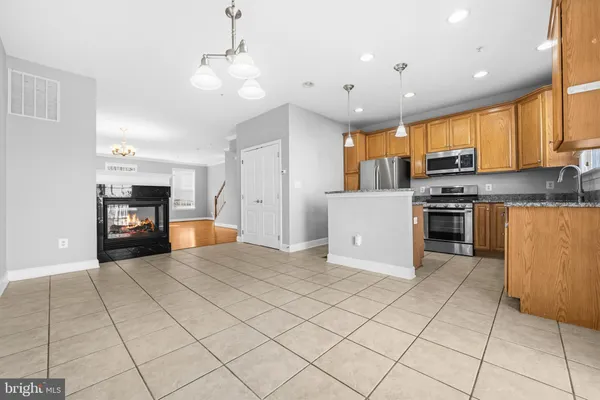 a kitchen with stainless steel appliances granite countertop a refrigerator a stove top oven a sink and dishwasher