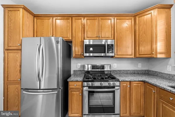 a kitchen with stainless steel appliances granite countertop a refrigerator stove and microwave