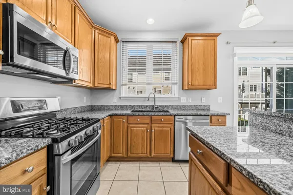 a kitchen with stainless steel appliances granite countertop a sink stove and microwave