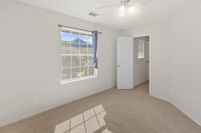 an empty room with windows and closet