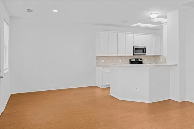 a view of a kitchen with cabinets and a wooden floor